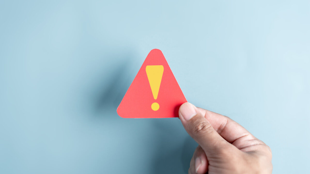 System warning caution sign symbol paper cut out. Notification error and maintenance concept. cyber attack on computer network. Cybersecurity vulnerability, data breach, illegal connection, compromised information.